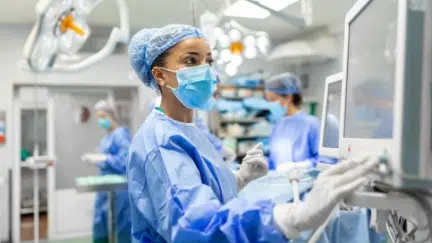 Healthcare professional using a digital system in a clinical setting, representing HIPAA-compliant portal and real-time analytics for healthcare operations